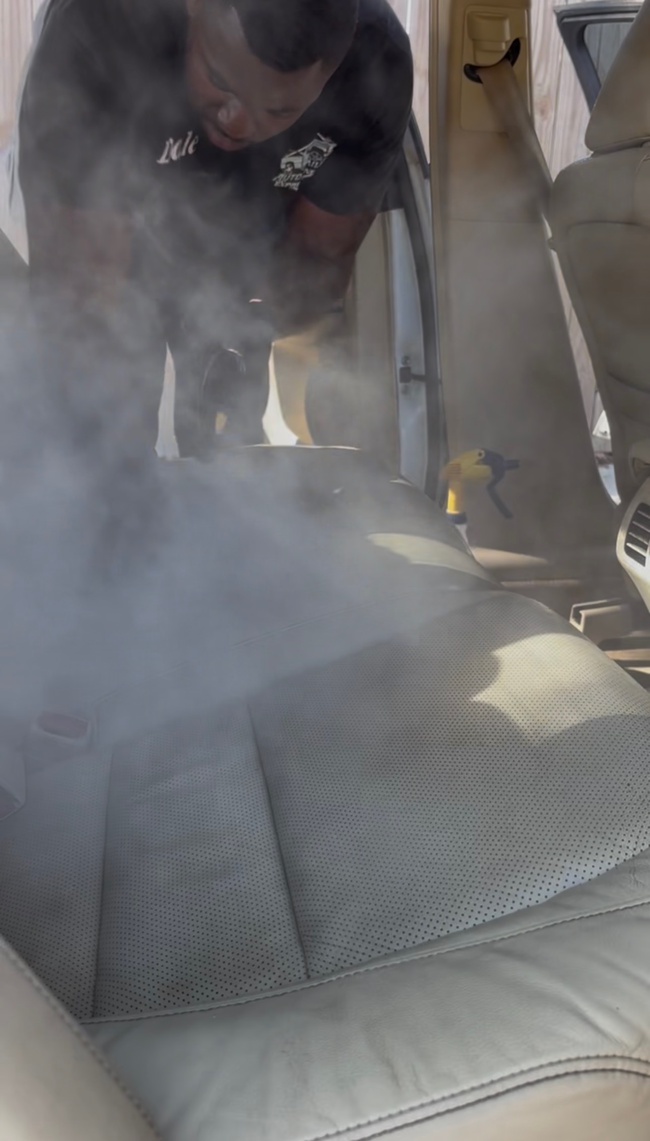 Steam cleaning dashboard vents, cup holders, panels, and crevices during mobile car detailing in Baton Rouge